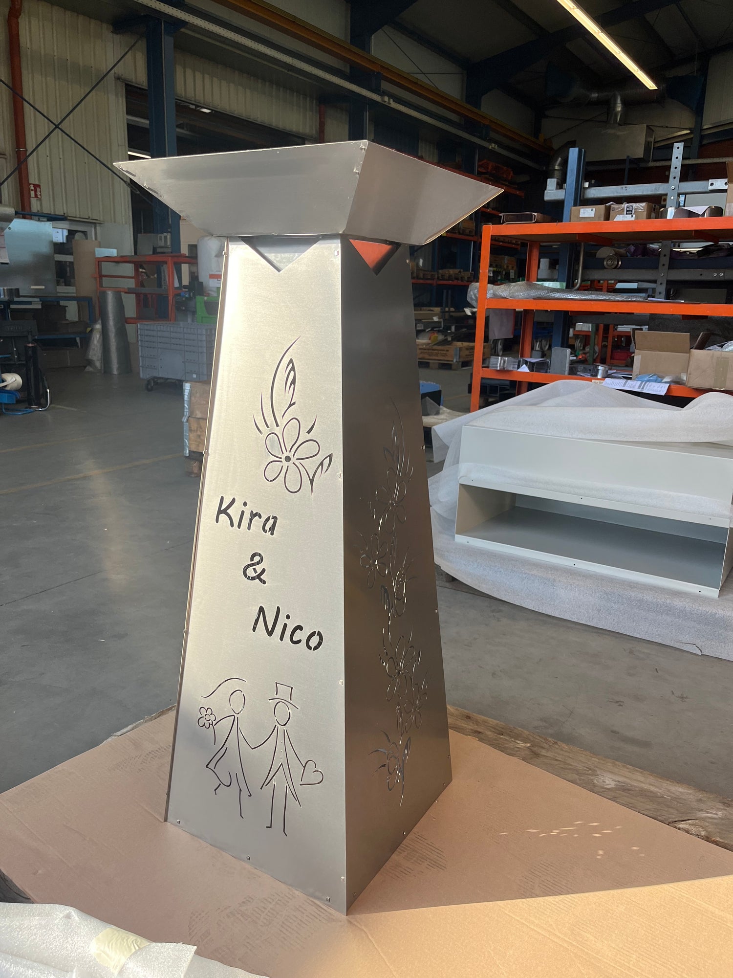 eckige Blumensäule mit einer Brautpaar Silhouette und Blumen