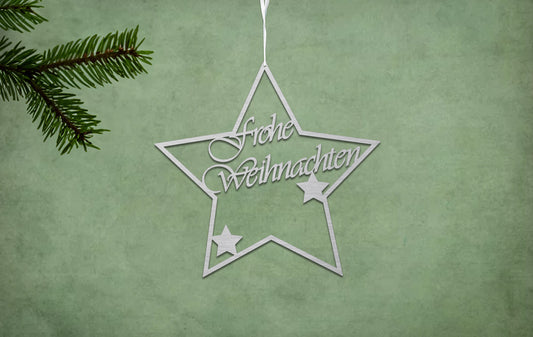 Silberner Deko Stern auf grünem Hintergrund. Mit der innen Schrift frohe Weihnachten und zwei weiteren Sternen in der Mitte.