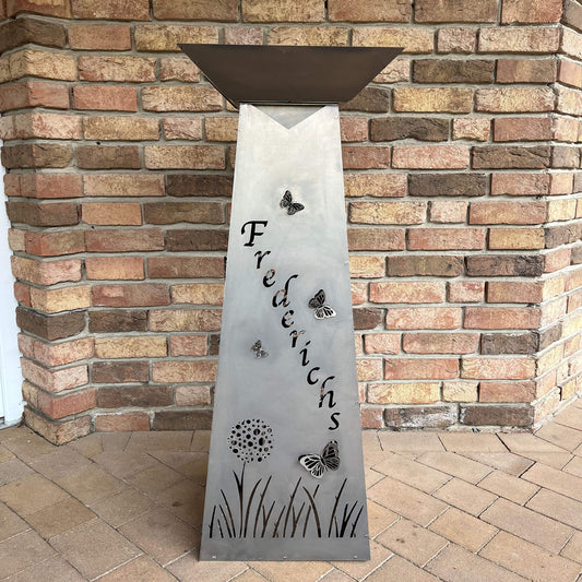 Seitenansicht auf eine rechteckige Pflanzensäule aus Metall. Mit Personalisierung, Schmetterlingen und Blumen.