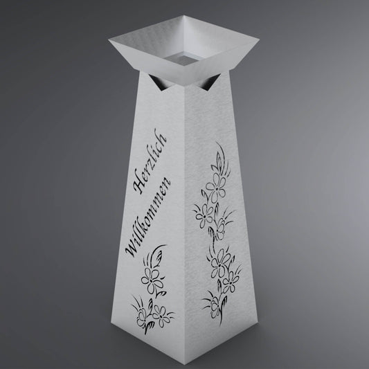 Metallsäule mit Vorderseite und Rückseite Herzlich Willkommen Motiv und an den Seiten Blumenranken.