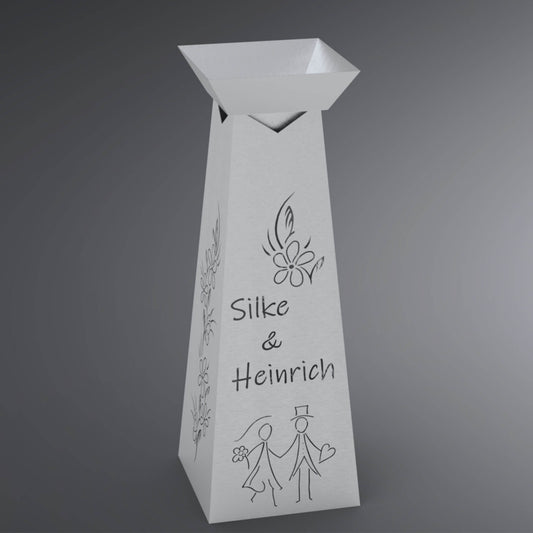 Blumensäule mit Silhouette eines Hochzeitspaares unten, darüber Namen und eine kleine Blume.