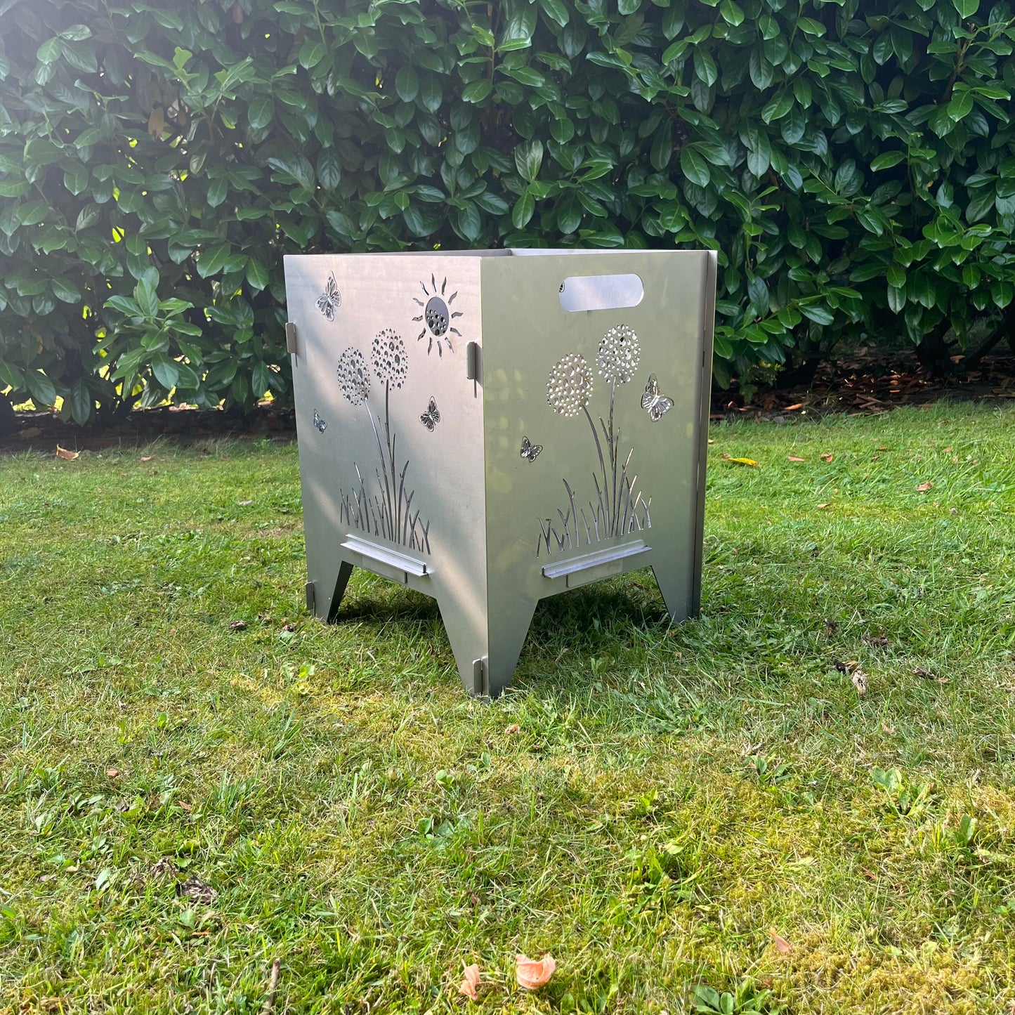 Feuertonne in der Höhe 50 cm mit Pusteblumen und Schmetterlingen im Garten