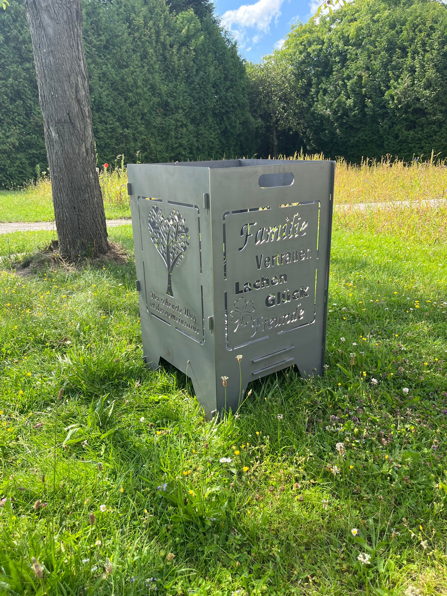 rechteckige Feuertonne mit Hochzeitsmotiv im Garten unter einem Baum