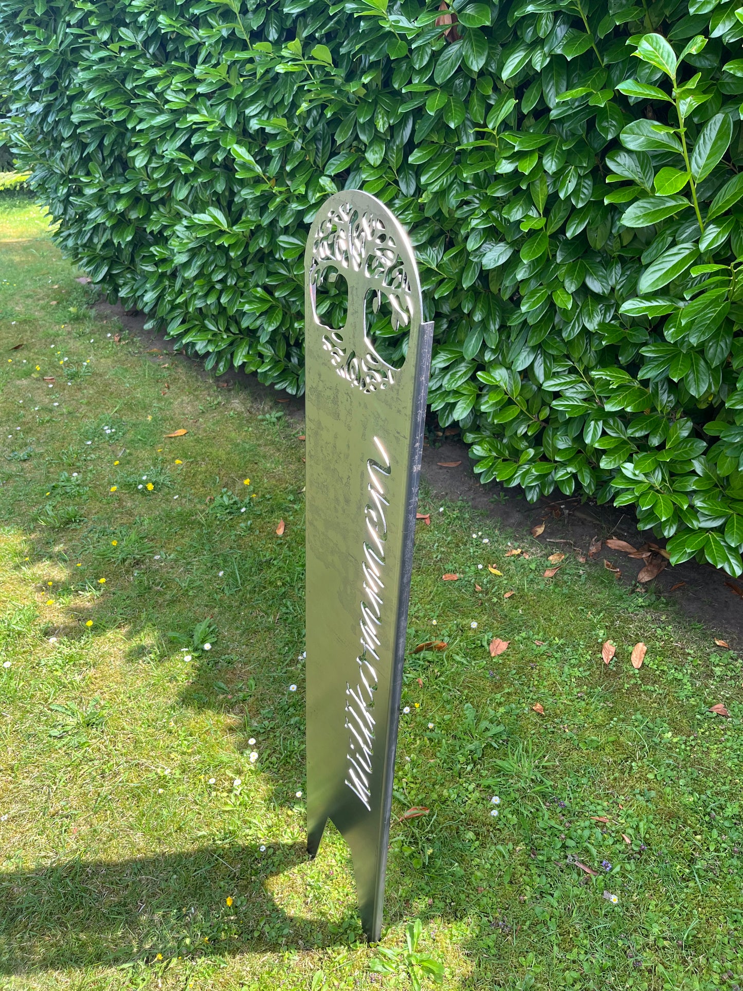 Gartenstecker auf Gras in silber mit Willkommen senkrecht im Garten schrägh von oben