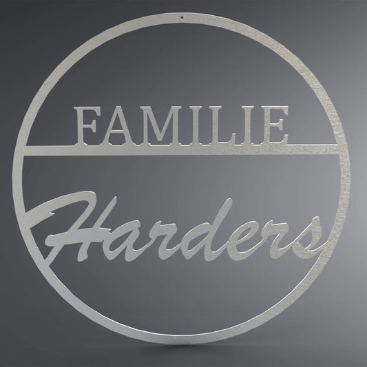 Dünner, ausgehöhlter Kreis. Oben steht in Druckbuchstaben auf einer Linie: "Familie". Da drunter steht verschnörkelt der Familienname.