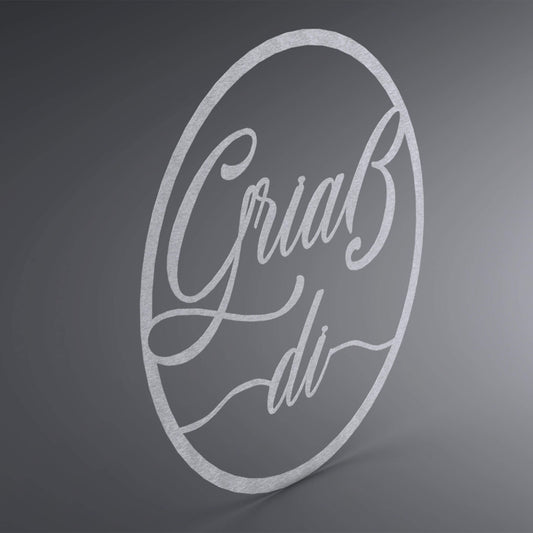 Dünner, ausgehöhlter Kreis. Über die komplette Lücke steht: "Griaß di" groß und verschnörkelt. Seitliche Ansicht.