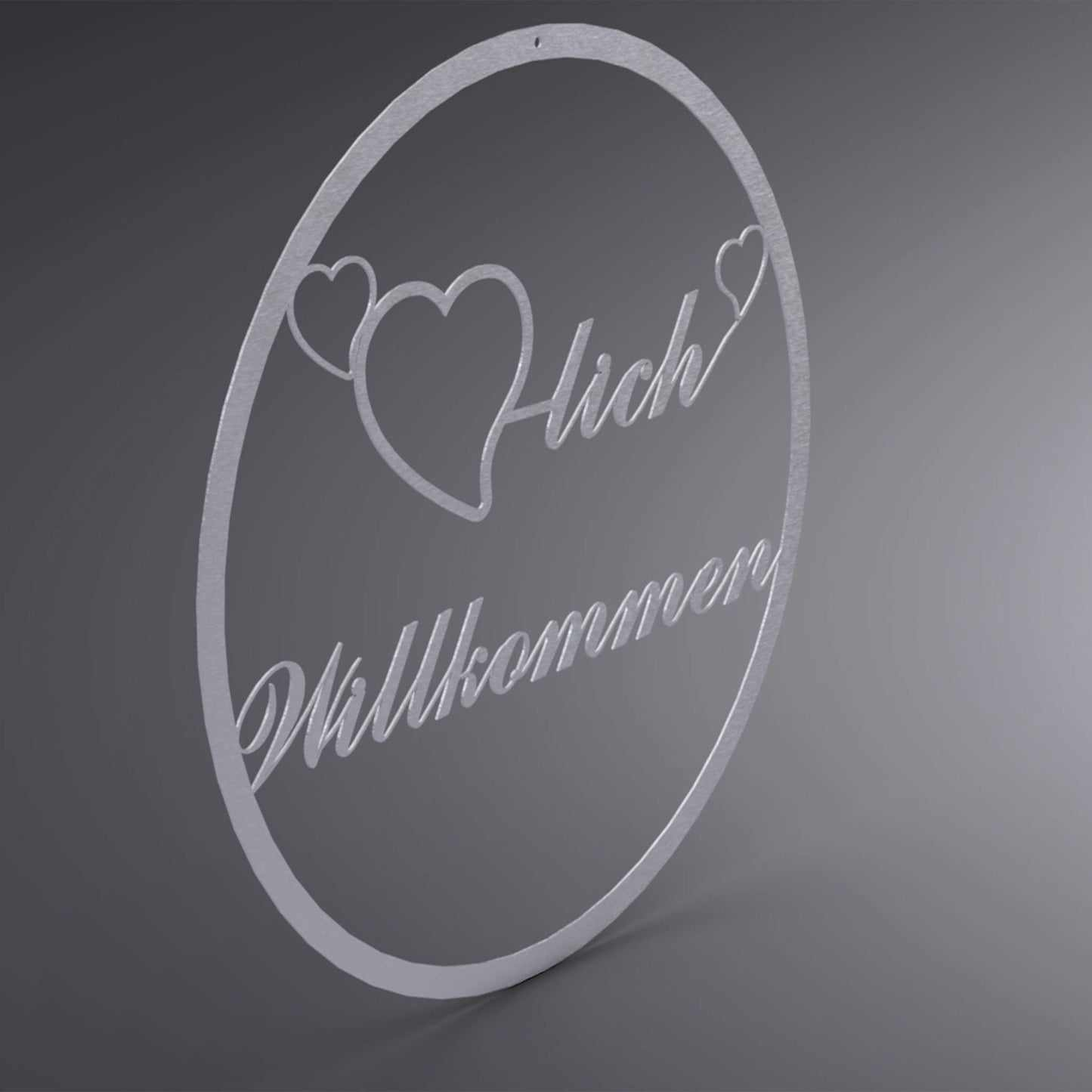 Dünner, ausgehöhlter Kranz. Mittig ist ein ausgehöhltes Herz verbunden mit dem Wort: "-lich". Auf beiden Seiten befindet sich noch ein kleines, ausgehöhltes Herz. Da drunter steht Willkommen verschnörkelt. Seitliche Ansicht.