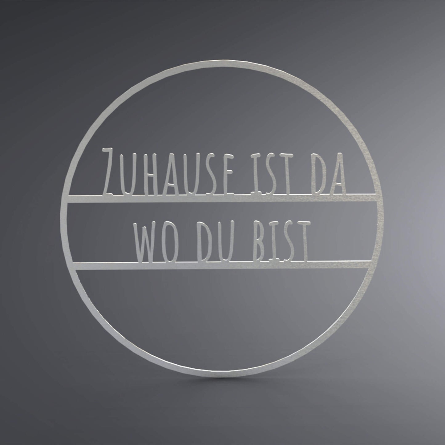 Dünner, ausgehöhlter Kreis. In der Mitte steht: "Zuhause ist da wo du bist".
