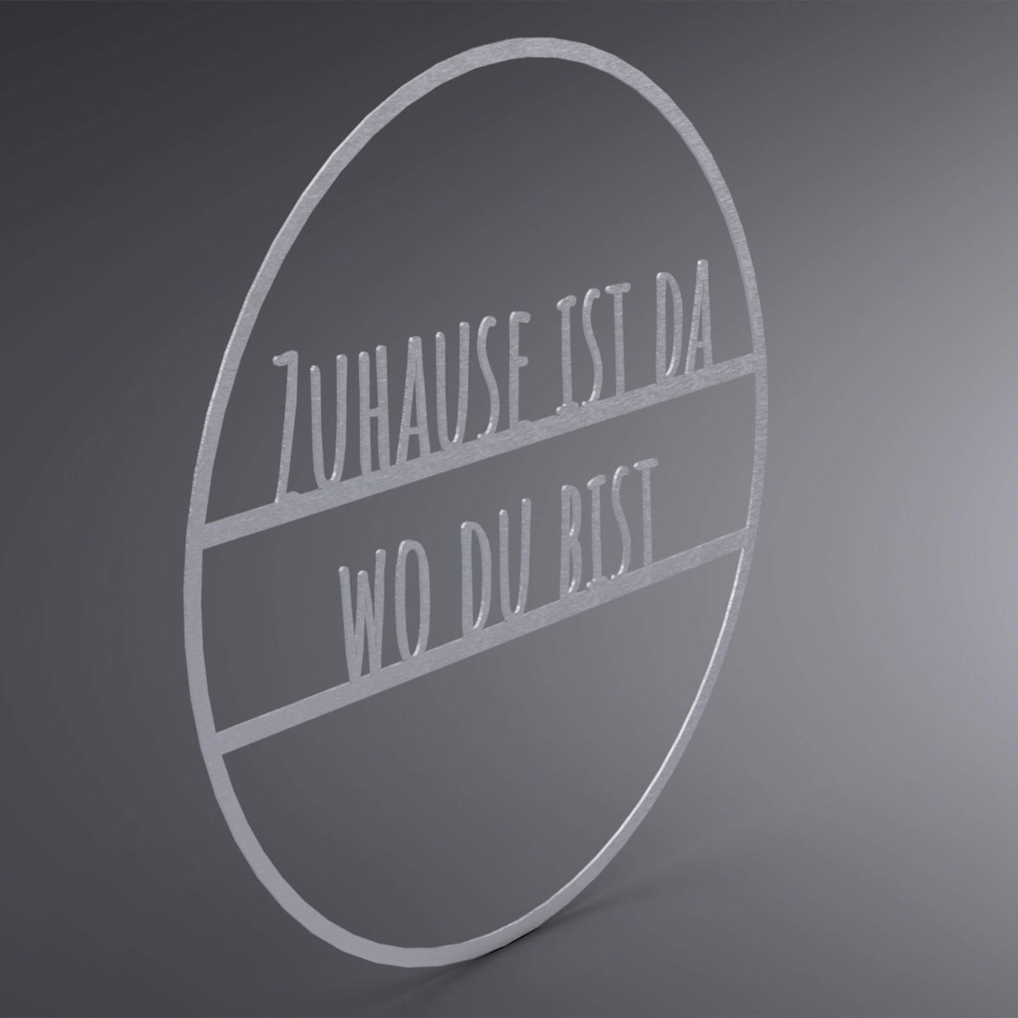 Dünner, ausgehöhlter Kreis. In der Mitte steht: "Zuhause ist da wo du bist". Seitliche Ansicht.