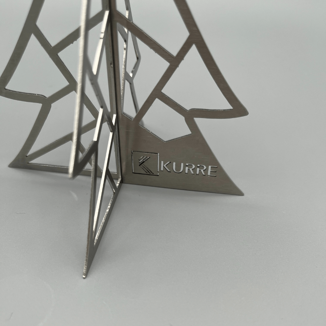 Gravur in einer unteren Ecke eines Weihnachtsbaums aus Metall. Platz für eine Personalisierung.