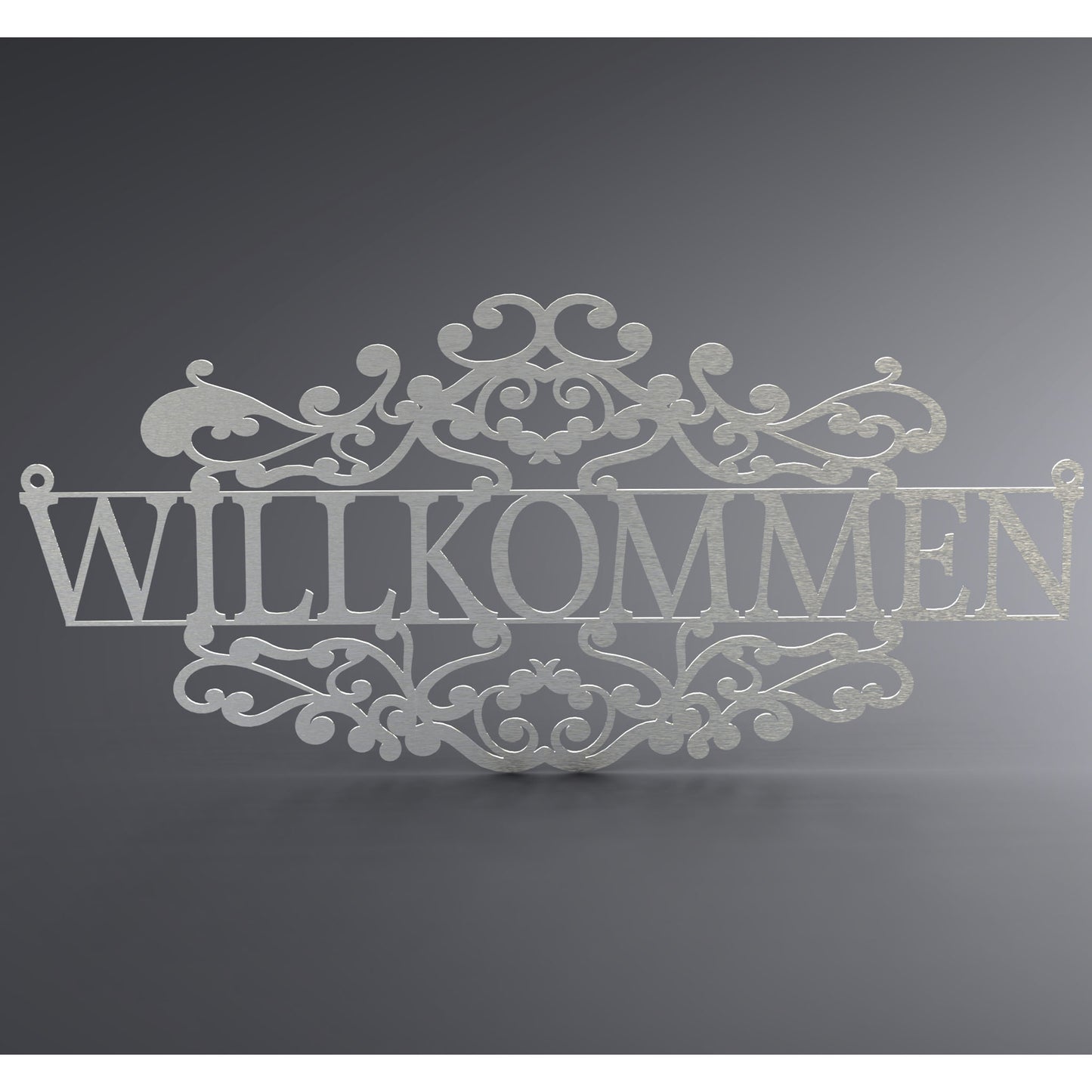 Eine Wanddekoration. In der Mitte steht: "Willkommen". Da drüber und da drunter knüpft ein verschnörkeltes Geflecht daran.
