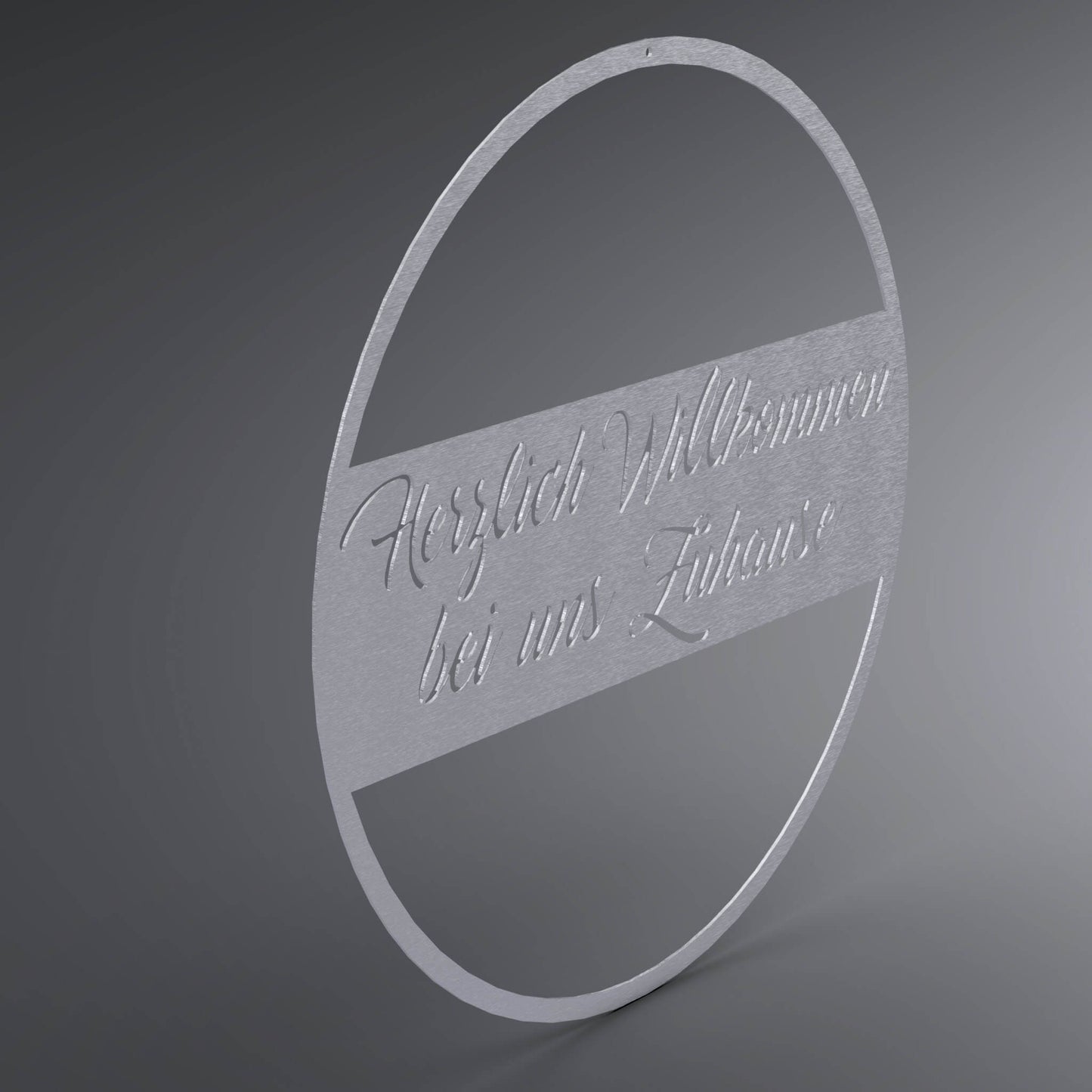 Dünner, ausgehöhlter Kreis. In der Mitte ist ein Balken. Darin steht der Spruch: "Herzlich Willkommen bei uns Zuhause" verschnörkelt. Seitliche Ansicht.