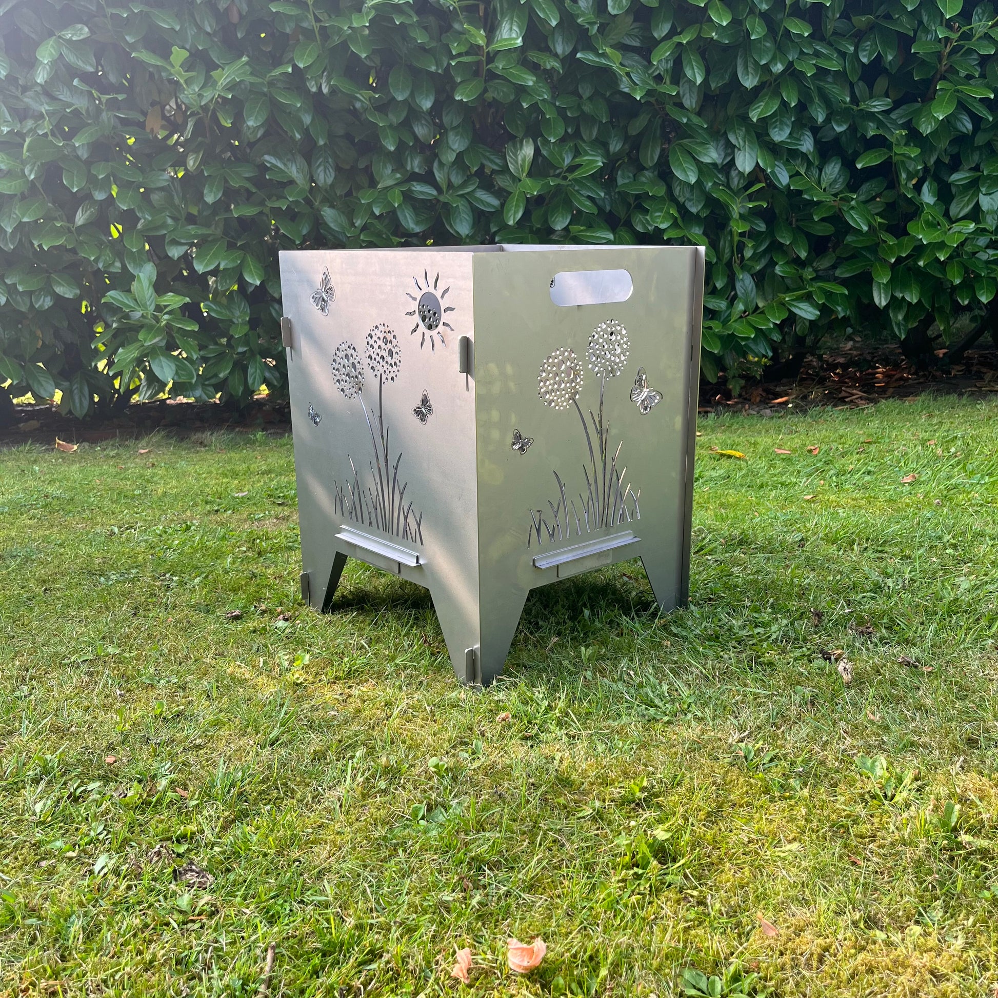 Feuertonne in der Höhe 50 cm mit Pusteblumen und Schmetterlingen im Garten