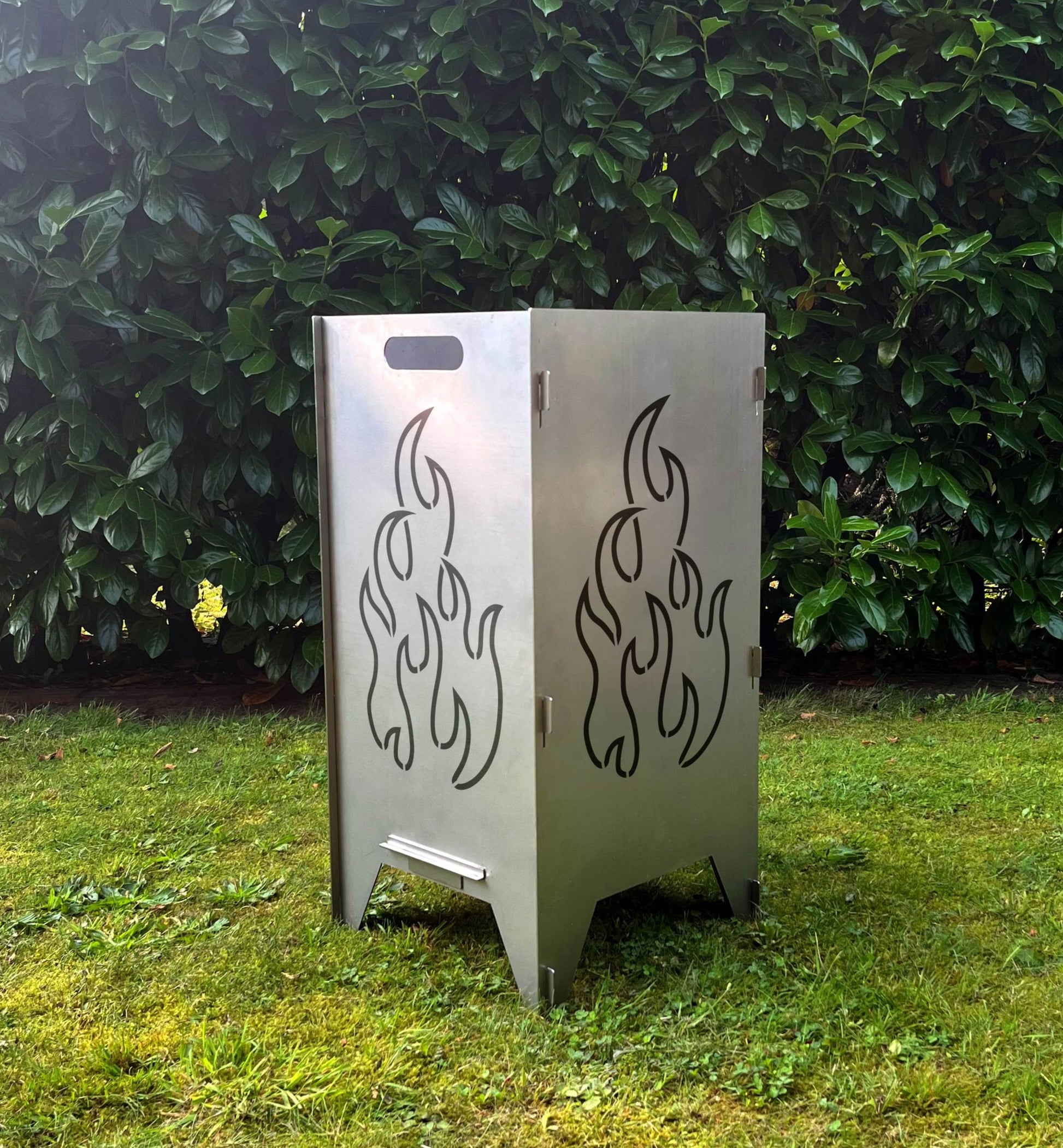 Feuertonne im Garten mit Flammen Motiv.