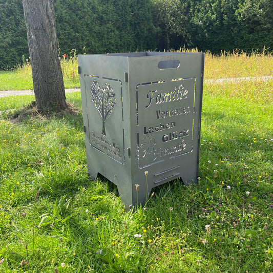 rechteckige Feuertonne mit Hochzeitsmotiv im Garten unter einem Baum auf einer Graswiese