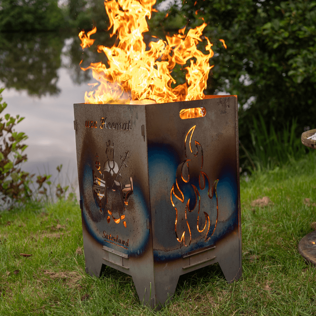 viereckige Feuertonne aus der Flammen kommen, an einem See stehend.