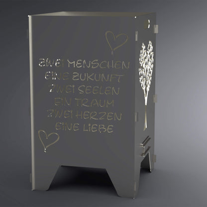 Feuertonne mit Spruch: "Zwei Menschen, eine Zukunft, zwei Seelen, ein Traum, zwei Herzen, eine Liebe" auf zwei Seiten. Zwei Seiten haben einen Herzförmigen Baum als Motiv. Spruch steht im Vordergrund.