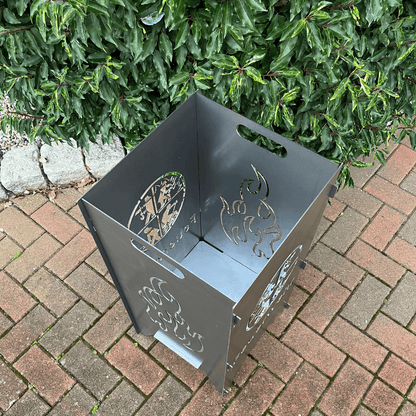 Feuertonne mit einem runden Feuerwehrwappen in der Mitte und darunter steht: "Feuerwehr" auf zwei Seiten. In dem runden Wappen sind Strichmännchen die verschiedenen Tätigkeiten nachgehen. Auf den anderen beiden Seiten befindet sich das Flammen-Motiv. Ansicht von oben.