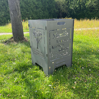 rechteckige Feuertonne mit Hochzeitsmotiv im Garten unter einem Baum auf einer Graswiese. Feuertonnen zur Hochzeit mit passendem Motiv.