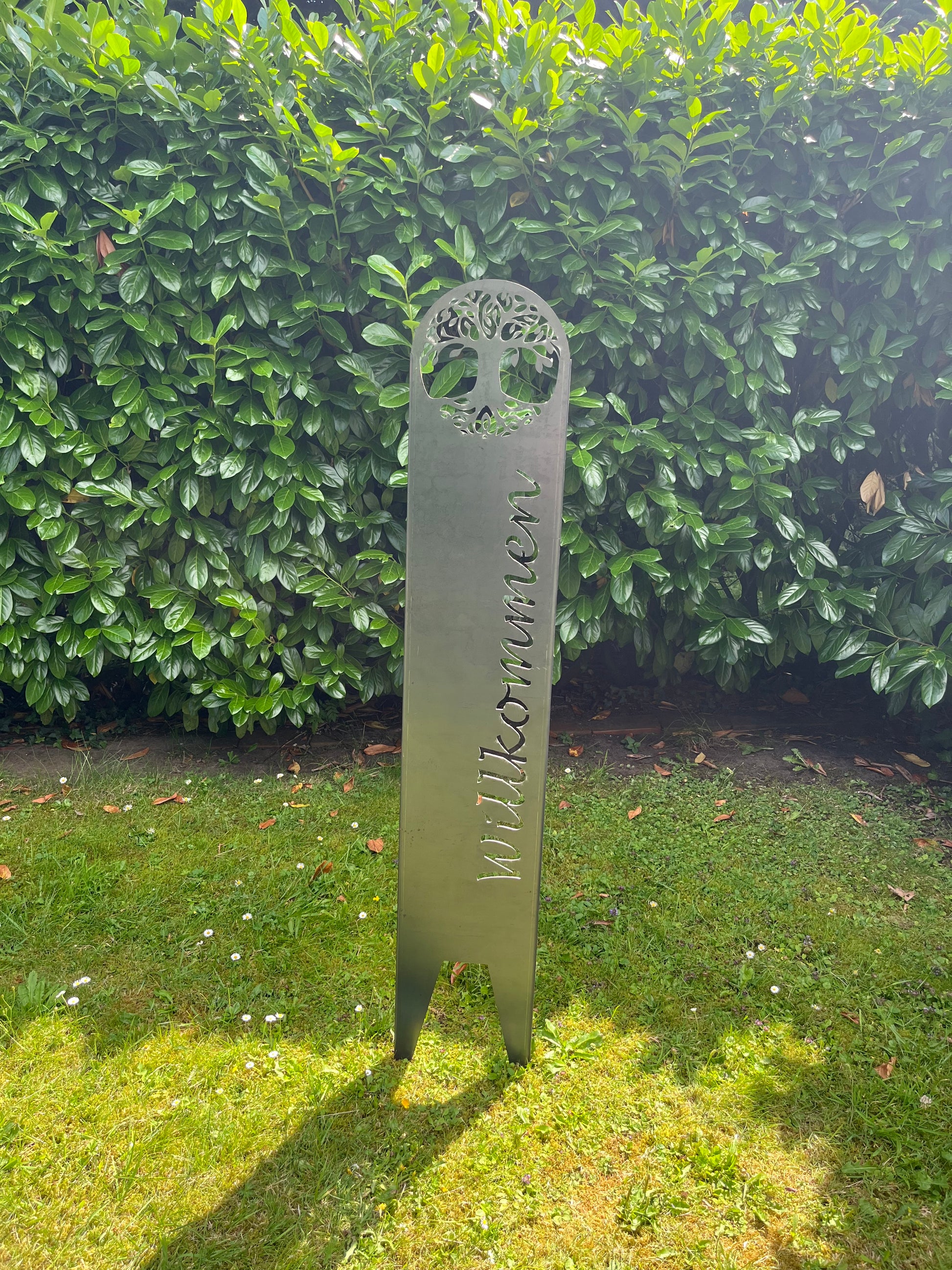 Senkrechter Schriftzug auf Gartenstecker in silber im Garten