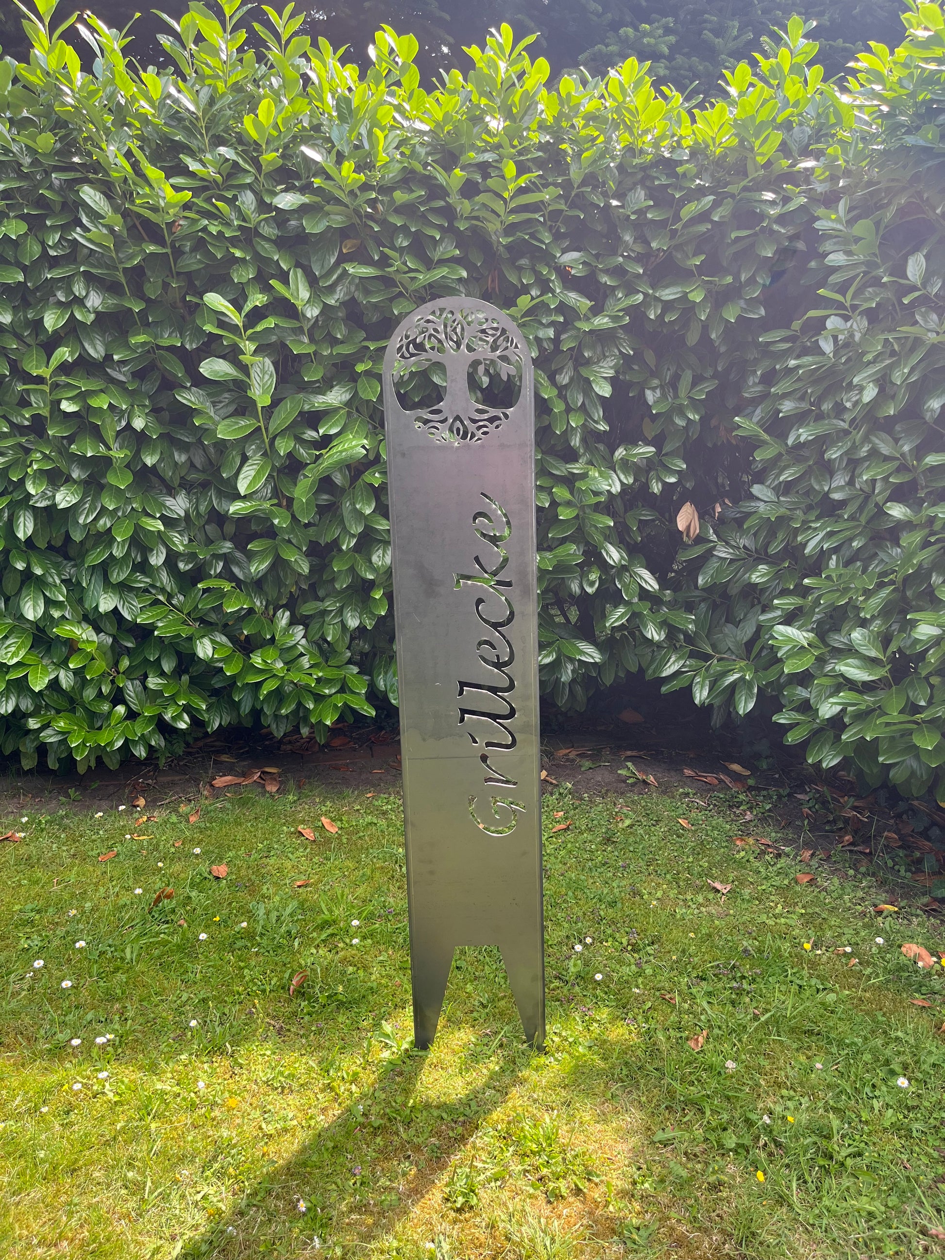 Gartenstecker im Garten in Silber mit ausgelaserter Schrift Grillecke und Baum