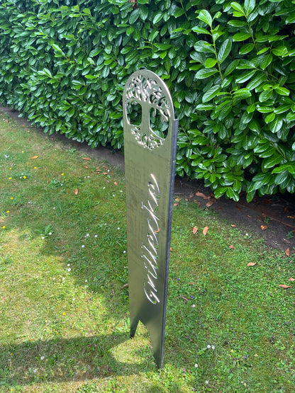 Seitenansicht im Garten auf einen Gartenstecker mit Schriftzug Grillecke 