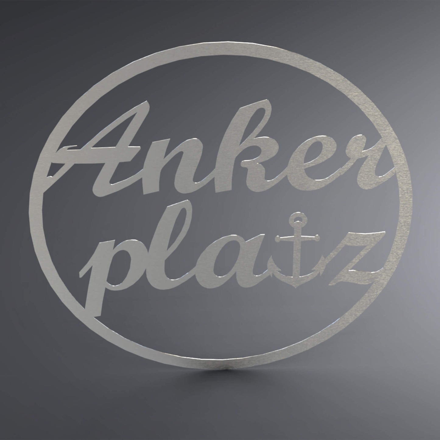 Dünner, ausgehöhlter Kreis. Über die komplette Lücke steht: "Ankerplatz" groß und verschnörkelt. Das t wurde gegen einen Anker ersetzt.