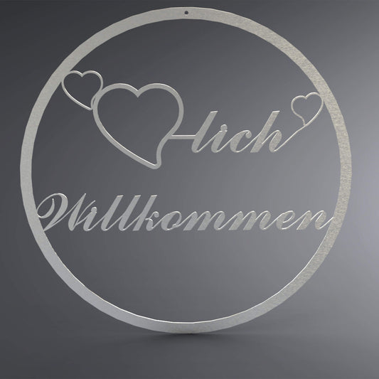 Dünner, ausgehöhlter Kranz. Mittig ist ein ausgehöhltes Herz verbunden mit dem Wort: "-lich". Auf beiden Seiten befindet sich noch ein kleines, ausgehöhltes Herz. Da drunter steht Willkommen verschnörkelt.