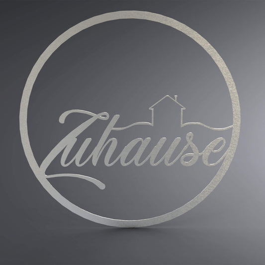 Dünner, ausgehöhlter Kreis. In der Mitte steht verschnörkelt Zuhause. Da drüber ist ein Haus mit dünnen Linien abgebildet.